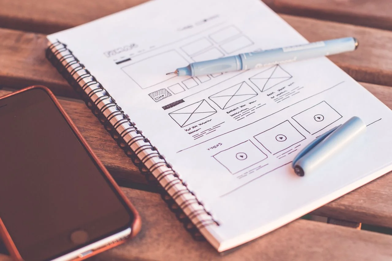 bozzetti-wireframe-e-prototipo-ux-ui-design-su-quaderno-con-smartphone